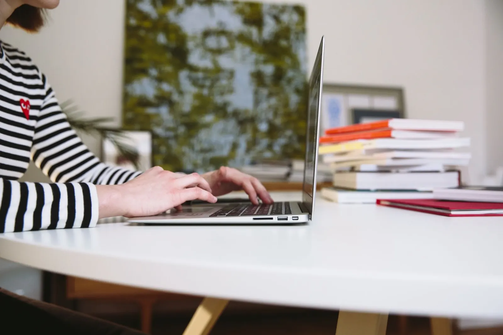 Mains sur le clavier d'un ordinateur portable, en train de rédiger une page de site internet
